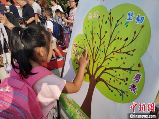 图为衡水市利民路小学，孩子们在成长树的“好习惯”树枝上按手印做出承诺。张松 摄